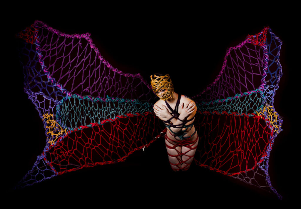 Nella Metamorfosi, ali di corda collegano
il Cielo e la Terra, legami che uniscono
dalla nascita e nutrono nella vita.
Solo all’apparizione della morte, la
corda viene tagliata, svelando l’essenza
nascosta,
La paura di volare si libera dai suoi
legami in un viaggio all’interno della
Metamorfosi.
La morte non è che la dolorosa trasmutazione,
presente, preparatoria, temporanea
della crisalide che ha in sé la magia della
perfezione immortale: la farfalla.
La creatura che ne esce diventa rinascita,
passaggio da uno stato di torpore
a uno stato di meraviglia, verso una nuova
Via.
Rinascita in totale trasformazione,
incontenibile creatività in un infinito
potenziale di abilità a sperimentare la
bellezza oltre la dualità e divenire capace
di volare verso il non giudizio e trascendere
verso la grande trasformazione del
cammino di ritorno.